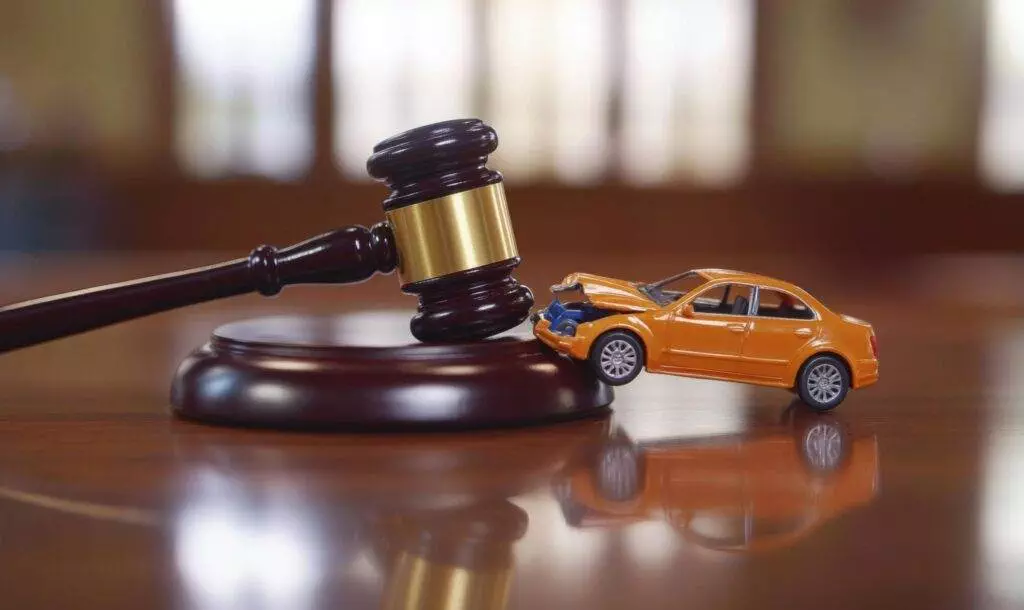 Gavel next to a toy car, symbolizing legal issues related to car accidents, ideal for a lawyer's context.